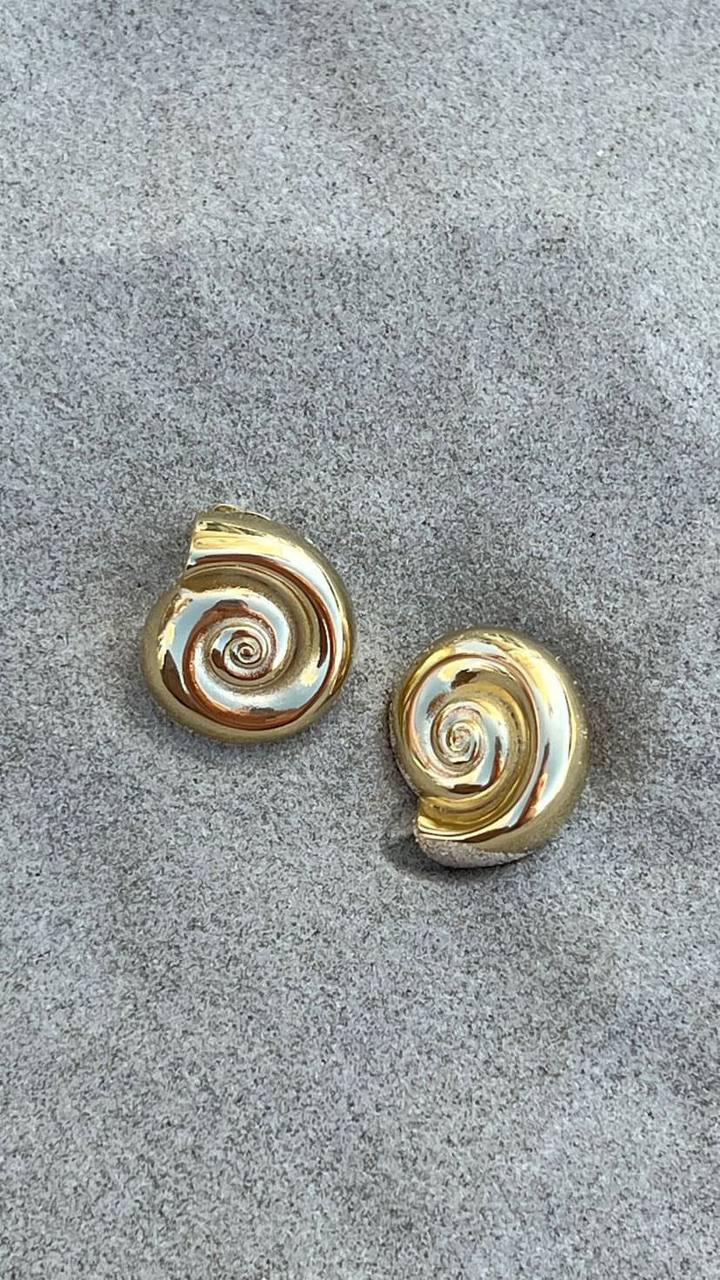 Elegant, round 18k gold-plated earrings featuring a delicate sea shell design, perfect for adding a touch of coastal charm to any outfit.