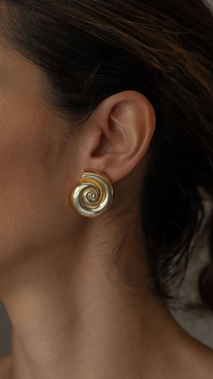 Elegant, round 18k gold-plated earrings featuring a delicate sea shell design, perfect for adding a touch of coastal charm to any outfit.